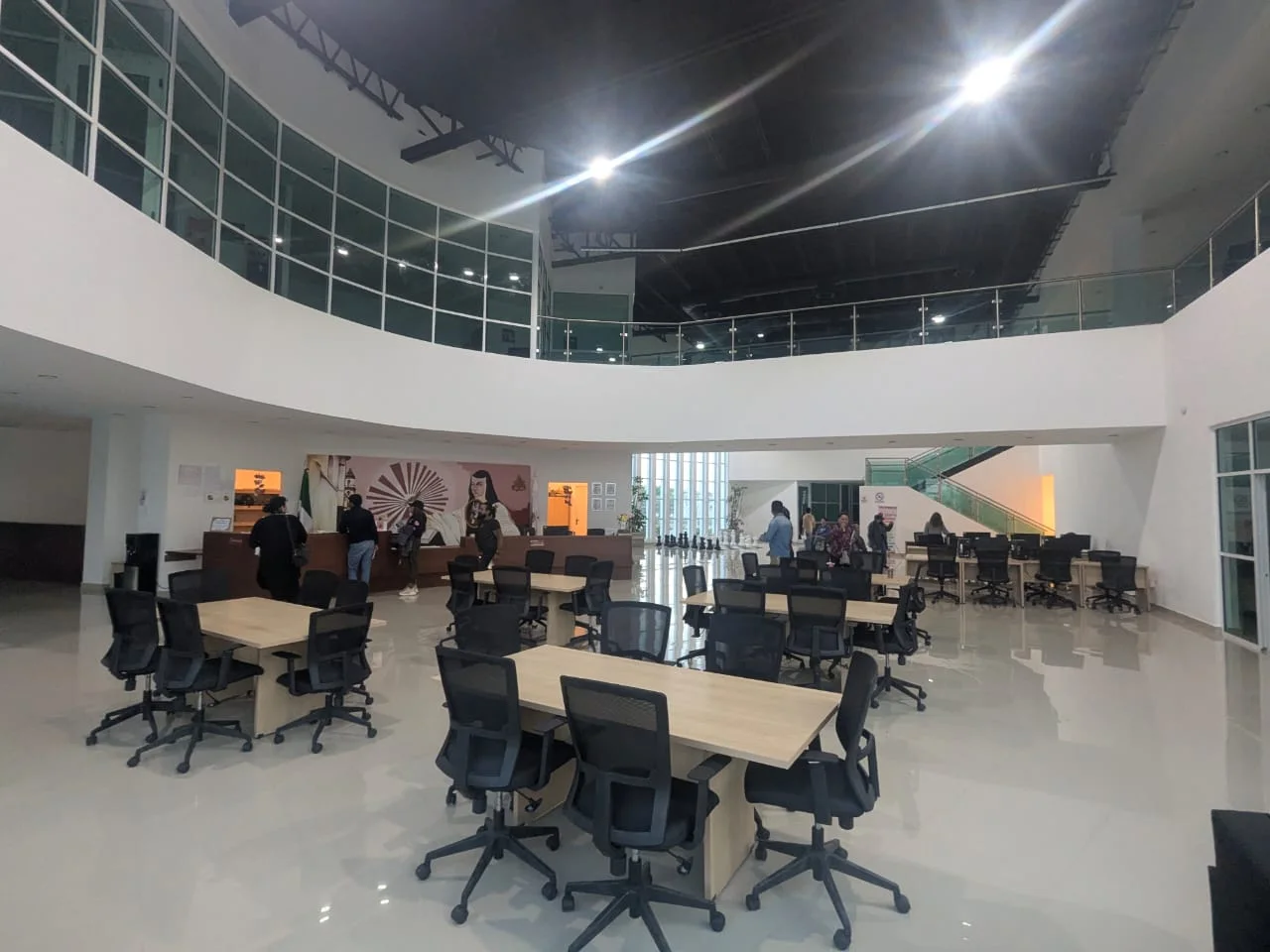 Lobby principal de la Infoteca, punto de bienvenida con luz natural y atmósfera abierta para recibir a la comunidad INNOVA